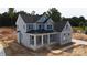 New two-story home boasts a covered front porch with white columns and light blue siding with a dark roof at 4251 Candlewood Dr, Sherrills Ford, NC 28673
