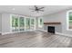 Light-filled living room with a ceiling fan, fireplace, and glass sliding doors at 4251 Candlewood Dr, Sherrills Ford, NC 28673