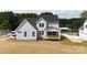 View of the back exterior featuring a charming covered porch perfect for relaxation, set against a backdrop of lush greenery at 4251 Candlewood Dr, Sherrills Ford, NC 28673