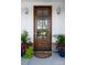 Elegant front door with glass panels, flanked by planters with colorful flowers and greenery at 4257 Candlewood Dr # 7, Sherrills Ford, NC 28673