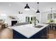 Modern kitchen island with white countertop overlooking a living room with a fireplace, plus a dining area at 4257 Candlewood Dr # 7, Sherrills Ford, NC 28673