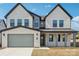 Beautiful two-story home featuring a brick facade, attached garage, and covered front porch with modern dark frame windows at 604 Hyder Trl, Tega Cay, SC 29708