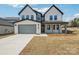 Charming two-story house featuring a brick facade, front-entry garage, covered front porch, and well-manicured lawn at 604 Hyder Trl, Tega Cay, SC 29708