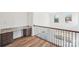 Hallway features a built-in desk, hardwood floors, and wrought iron railing at 604 Hyder Trl, Tega Cay, SC 29708