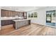 Lovely kitchen with a spacious island, wood flooring, custom cabinetry, and a large window for natural light at 604 Hyder Trl, Tega Cay, SC 29708