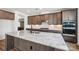 Modern kitchen featuring custom cabinets, stainless appliances, marble countertops and backsplash, and wood flooring at 604 Hyder Trl, Tega Cay, SC 29708