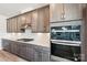 Close up of stainless steel oven inside a kitchen with marble countertops, custom cabinets, and wood flooring at 604 Hyder Trl, Tega Cay, SC 29708