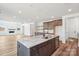 Bright kitchen with a large island, granite counters, stainless appliances, flowing into the living area with fireplace at 604 Hyder Trl, Tega Cay, SC 29708