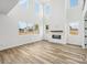 Sun-filled living room with a modern fireplace, high ceilings, and large windows at 604 Hyder Trl, Tega Cay, SC 29708