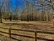 Open field with walking path surrounded by trees and wooden fence at 85 5Th St, Cramerton, NC 28032