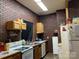 Eat-in kitchen with brick walls, ample counter space, white appliances, and wooden cabinets at 85 5Th St, Cramerton, NC 28032