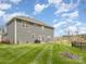 Large backyard with gray house and grassy area at 8903 Ansley Park Pl, Huntersville, NC 28078