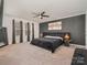 Main bedroom with a plush bed, dark accent wall, and ceiling fan at 8903 Ansley Park Pl, Huntersville, NC 28078