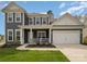 Gray two-story house with white trim, front porch, and attached garage at 8903 Ansley Park Pl, Huntersville, NC 28078