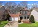 Charming brick home with a well-manicured lawn, two-car garage and inviting front porch at 1027 Forbishire Dr, Matthews, NC 28104