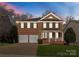 Classic two-story brick home with attached two-car garage and manicured lawn at 1027 Forbishire Dr, Matthews, NC 28104