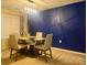 Dining area with a glass table, four chairs, and a blue accent wall at 11627 Tribal Dr, Charlotte, NC 28214