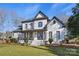 Two-story white brick home with gray accents, a front porch, and manicured lawn at 11917 James Jack Ln, Charlotte, NC 28277