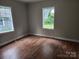 Spacious bedroom with wood floors, neutral walls, and two windows at 1300 Brookdale St, Kannapolis, NC 28083
