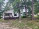 White house with brown trim, front porch, and large trees in the yard at 1300 Brookdale St, Kannapolis, NC 28083