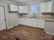 Simple kitchen with white cabinets, wood floors, and neutral walls at 1300 Brookdale St, Kannapolis, NC 28083