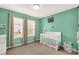 Bedroom with crib, changing table, and mint green walls at 1444 Swaying Branch Ln, Clover, SC 29710