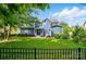 Spacious backyard with lush green grass, mature trees, and a wrought iron fence for privacy at 2607 White Pines Ct, Monroe, NC 28112