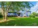 Expansive backyard featuring a well-maintained lawn, patio, and mature trees, perfect for outdoor activities at 2607 White Pines Ct, Monroe, NC 28112