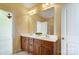 A bathroom with a double vanity, white countertops, and a large mirror with decorative lighting at 2607 White Pines Ct, Monroe, NC 28112