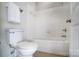 A view of a bathroom showcasing a toilet, bathtub, and shower with a white tiled wall at 2607 White Pines Ct, Monroe, NC 28112
