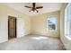 An empty bedroom featuring neutral paint, trim, carpet, ceiling fan, and a window allowing natural light at 2607 White Pines Ct, Monroe, NC 28112