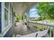 Covered front porch with a swing, stone flooring, and ceiling fans for outdoor comfort at 2607 White Pines Ct, Monroe, NC 28112