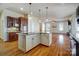 Kitchen with a large island with a cooktop and seating that opens to the living room at 2607 White Pines Ct, Monroe, NC 28112