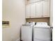 Laundry room with new front load washer and dryer and white wall cabinets at 2607 White Pines Ct, Monroe, NC 28112