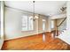 Bright living room with chandelier, windows, hardwood floors, and staircase leading to the upper level at 2607 White Pines Ct, Monroe, NC 28112