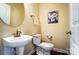 Cozy powder room with a pedestal sink, round mirror, and decorative art above the toilet at 2607 White Pines Ct, Monroe, NC 28112