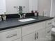 Dark countertop bathroom vanity with white cabinets and brushed nickel hardware at 303 Gurley St, Kannapolis, NC 28081