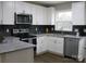 Modern white kitchen with granite countertops and stainless steel appliances at 303 Gurley St, Kannapolis, NC 28081