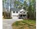 Charming two-story home with a covered front porch and attached garage, nestled in a wooded area at 5528 Brickstone Dr, Charlotte, NC 28227