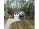 Two-story home featuring a covered front porch and an attached garage, situated on a spacious lot with mature trees at 5528 Brickstone Dr, Charlotte, NC 28227