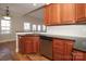 Beautiful kitchen with stainless steel dishwasher, dark countertops and cherry cabinets at 5727 Chalyce Ln, Charlotte, NC 28270