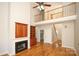 Bright living room featuring a fireplace, hardwood floors, and a view of the second-floor landing at 5727 Chalyce Ln, Charlotte, NC 28270