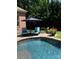 Tranquil pool area features lounge chairs, an umbrella, and lush greenery at 574 Barber Loop, Mooresville, NC 28117