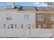 Rear view of townhome with white and brick siding, fenced yard at 9638 Longstone Ln, Charlotte, NC 28277