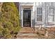 Townhouse entry with brick steps and black door at 9638 Longstone Ln, Charlotte, NC 28277