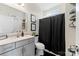 Clean bathroom with gray vanity, black shower curtain, and neutral decor at 10045 Carousel Corral Dr, Midland, NC 28107