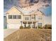 Two-story house with beige siding, a large front yard, and a two-car garage at 10045 Carousel Corral Dr, Midland, NC 28107