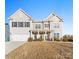 Two-story house with beige siding, a large front yard, and a two-car garage at 10045 Carousel Corral Dr, Midland, NC 28107