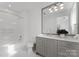 Bathroom featuring a shower and a gray vanity with a large mirror at 130 Cherokee Rd # 104, Charlotte, NC 28207