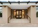 Elegant entryway featuring glass doors, stone accents, and accessible ramp with handrails at 130 Cherokee Rd # 104, Charlotte, NC 28207